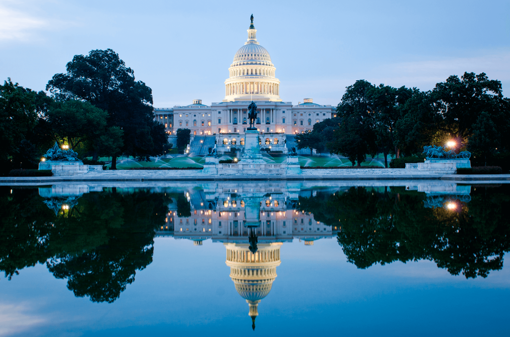 Washington DC, Edificio del Capitolio de Estados Unidos en un amanecer nublado con reflejo espejo