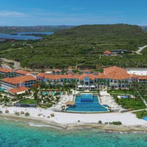 Cómodas sandalias de playa en color vibrante sobre arena dorada