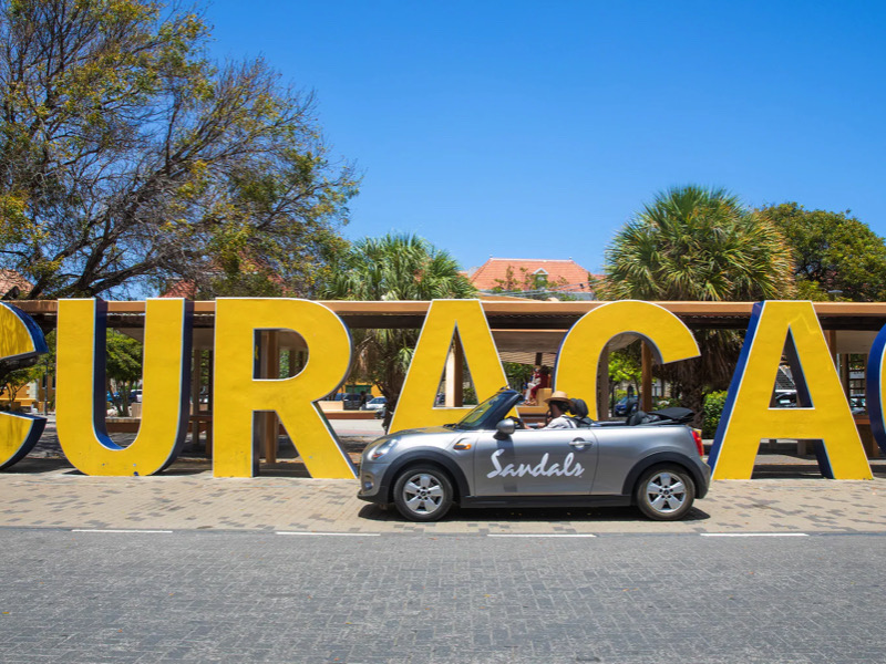Sandalias blancas elegantes para el verano con fondo de playa